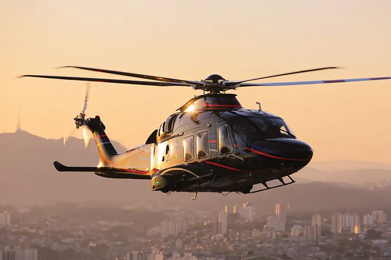 Helicóptero executivo sobrevoando a cidade ao pôr do sol